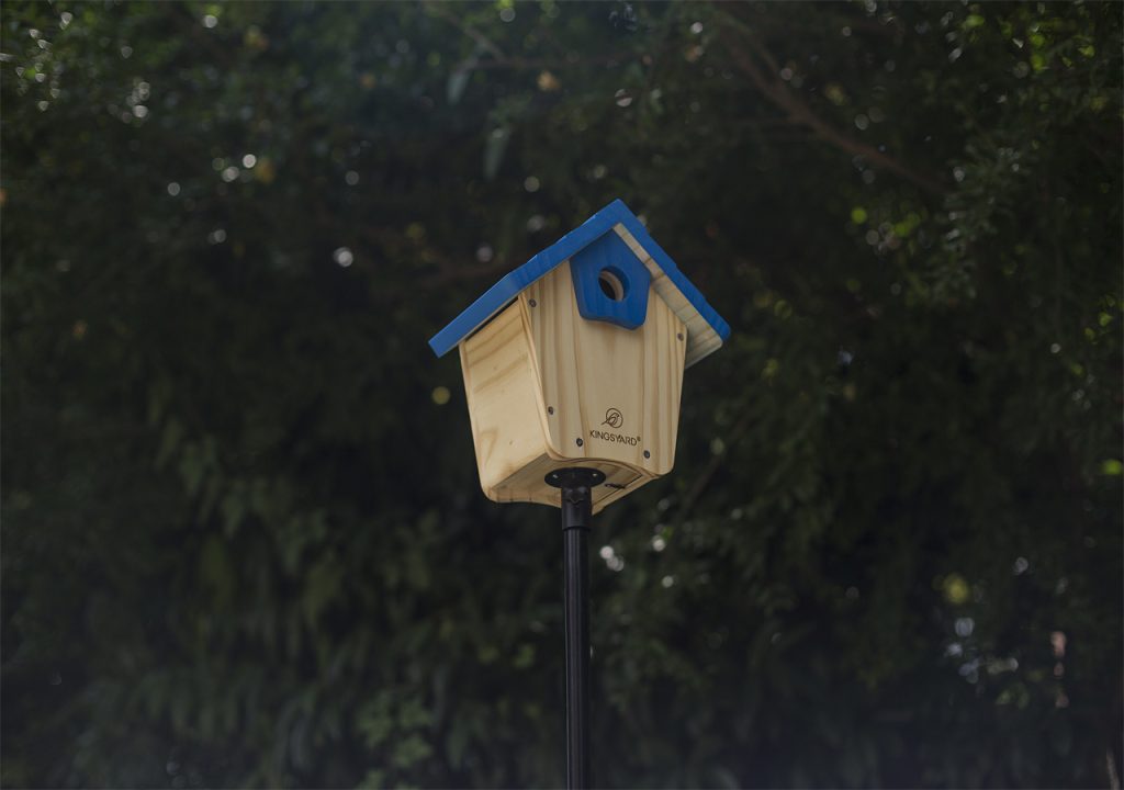 A Kingsyard wooden birdhouse with blue roof is installed on the pole, waiting for birds to come.